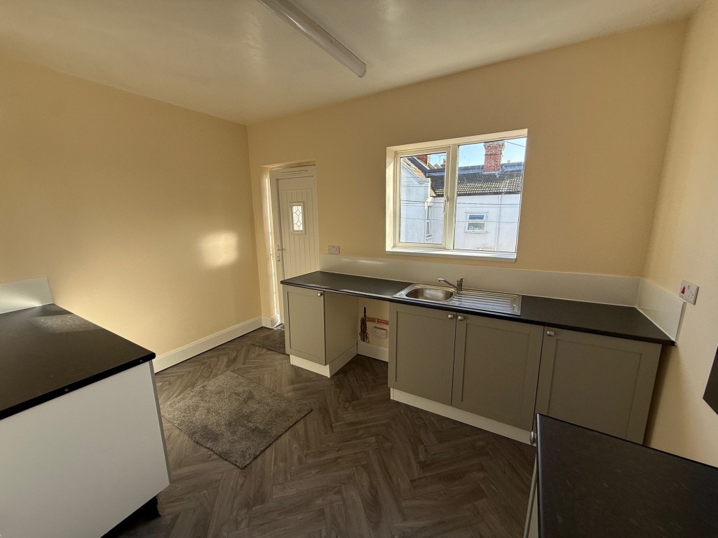 Lot: 63 - COMMERCIAL INVESTMENT WITH VACANT FLAT ABOVE - Alternative view of kitchen with window to rear